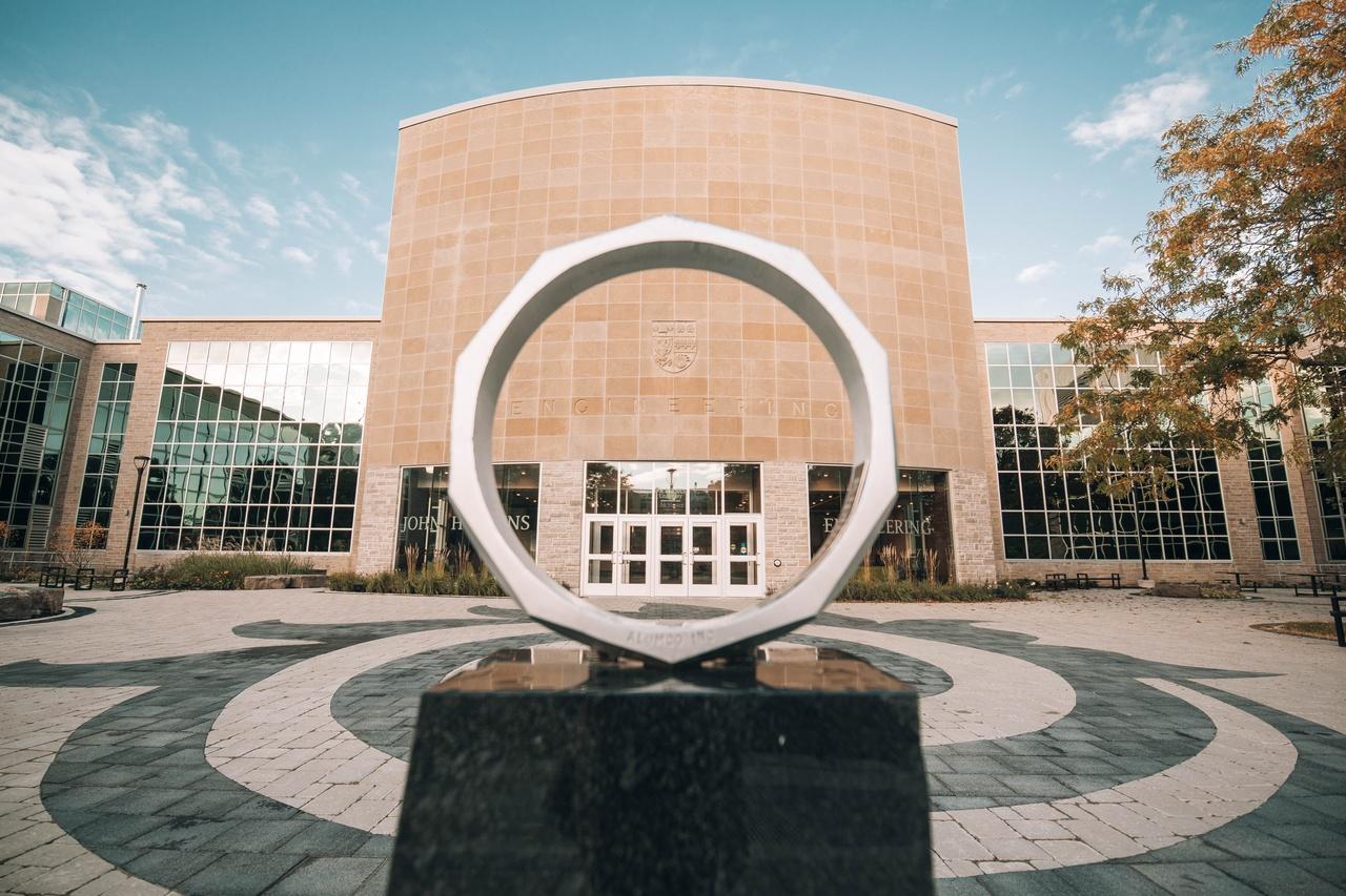 View of JHE through the iron ring sculpture.