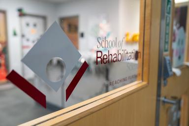 Close up of the School of Rehab Science logo on the office door.